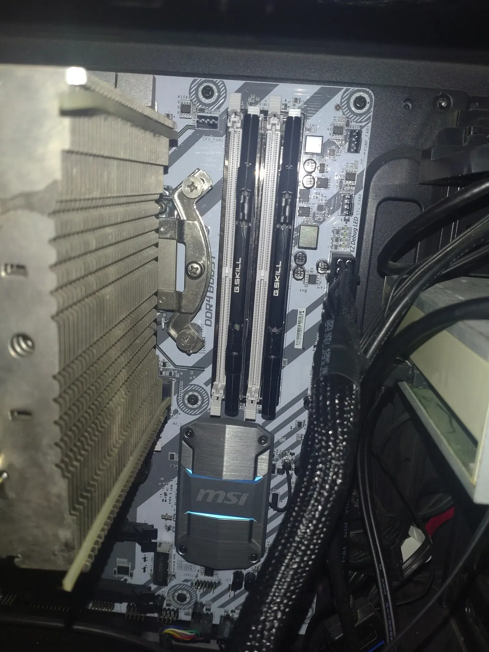 A motherboard with four slots and two sticks inserted in DIMMA2 and DIMMB2 slots, as recommended by the motherboard&#x27;s manual. There are two remaining slots, on each there is a visible keying notch which is supposed to fit the cutout of the correct gen like two matching puzzle pieces.